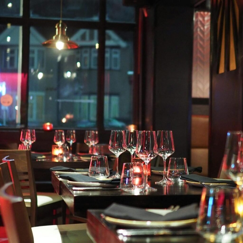 A sophisticated restaurant interior with elegant table setting and ambient candlelight, creating a cozy atmosphere.