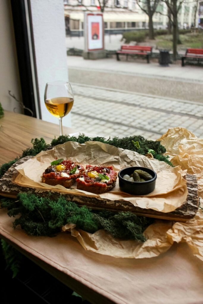 Rustic sandwiches with pickles and wine at a cozy café in Wrocław, Poland.
